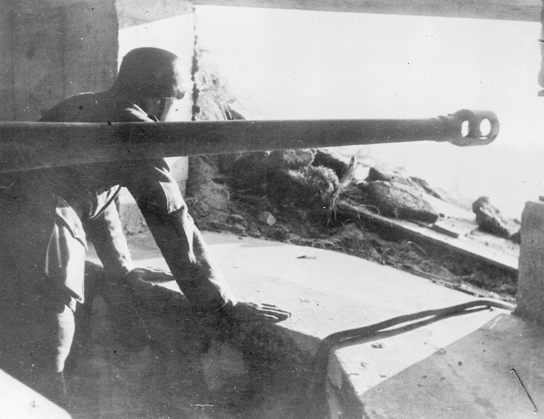 Peering warily from his concrete-reinforced gun emplacement, a German soldier contemplates the coming invasion of Europe.