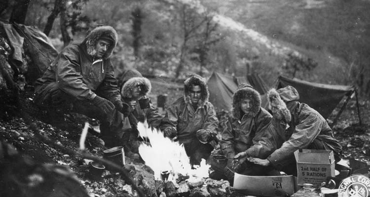 Pausing long enough to prepare rations, members of the 1st Special Service Force assess their situation while moving through the chilling cold of the Apennine Mountains near the town of Radicosa, Italy.