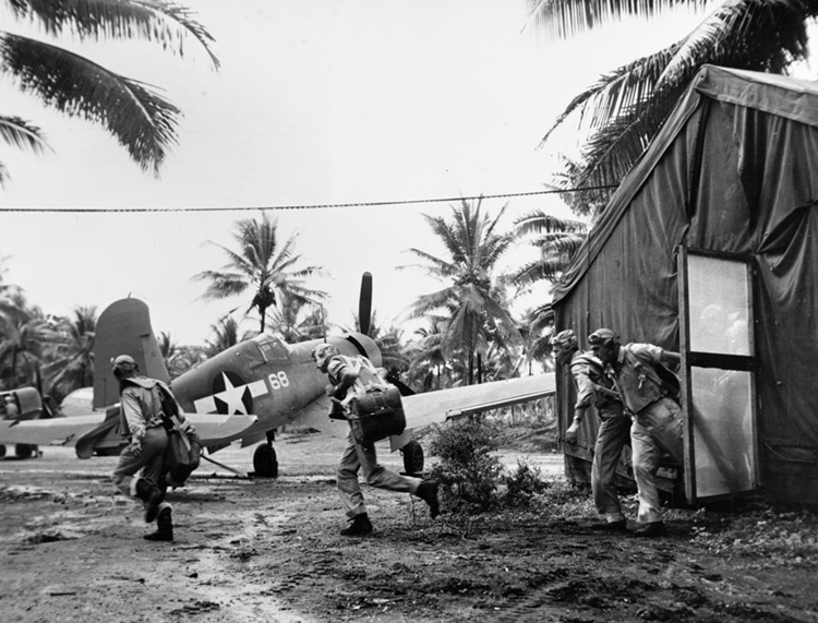 Marine VMF-214 “Black Sheep” F4U-1 squadron pilots based in the New Hebrides archipelago scramble for a mission. The Navy delayed the use of the F4U Corsair on its carriers because of problems associated with takeoffs and landings; however, Navy and Marine Corps squadrons operating from island airstrips in the Pacific Theater began using it in 1943.