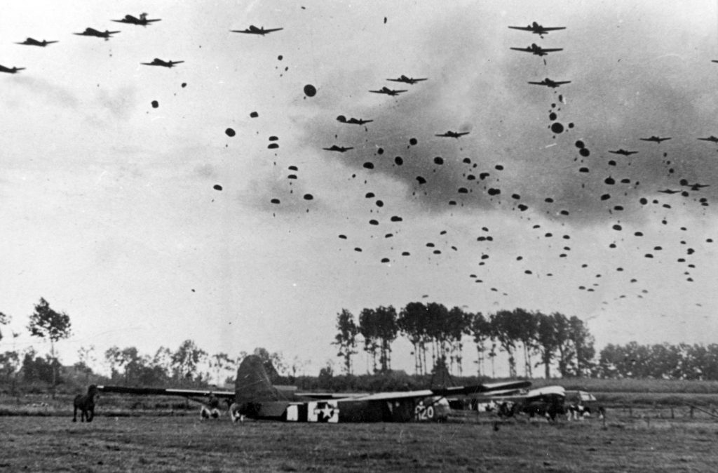 The sky near Wesel is filled with paratroopers descending from their C-47 transport planes over gliders that have already landed. 