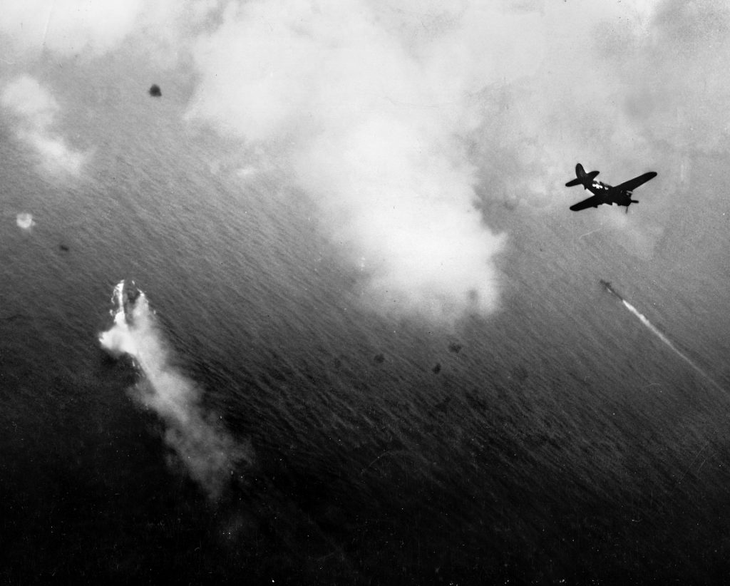 American divebombers, probably from the carrier USS Yorktown, prepare to attack the already buring Yamato (lower left).