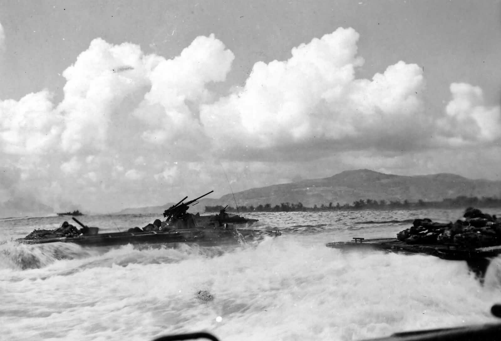  LVTs (Landing Vehicle, Tracked) known as “Buffalos” carry Marines through the surf on the way to a Saipan beachhead, June 15, 1944.