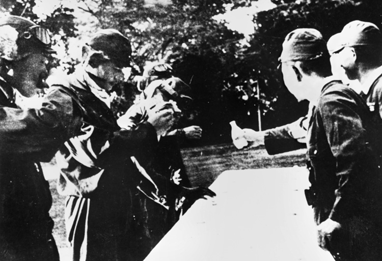 Admiral Takijiro Ohnishi (right), commander of the Kamikaze Special Attack Force, dispenses ceremonial cups of sake to suicide pilots about to take off.