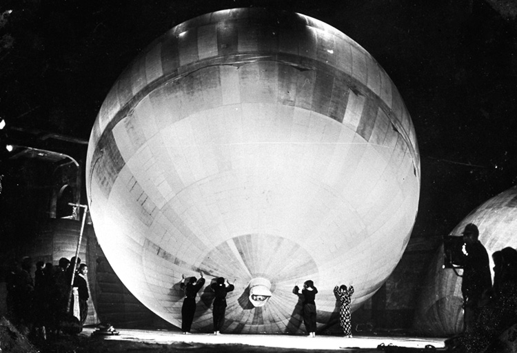 Japanese schoolgirls push one of the giant balloons across a factory floor during final inspection.