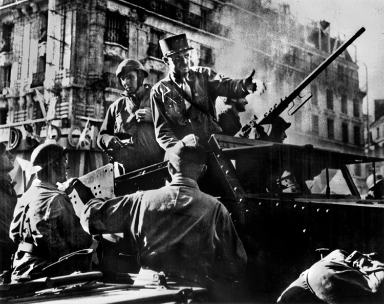 Determined to be the first into Paris, General Leclerc, standing in his halftrack, arrives after an all-out dash into the city.