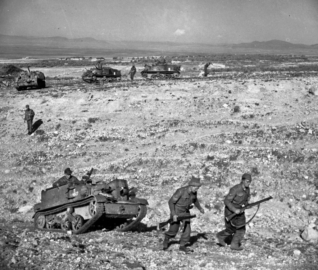  British infantry and carriers of the Grenadier guards advance over rugged ground near Kasserine Pass in late February. Lt. Gen. Kenneth Anderson, the commander of Allied forces in Tunisia, dispatched strong reinforcements to shore up the American sector.