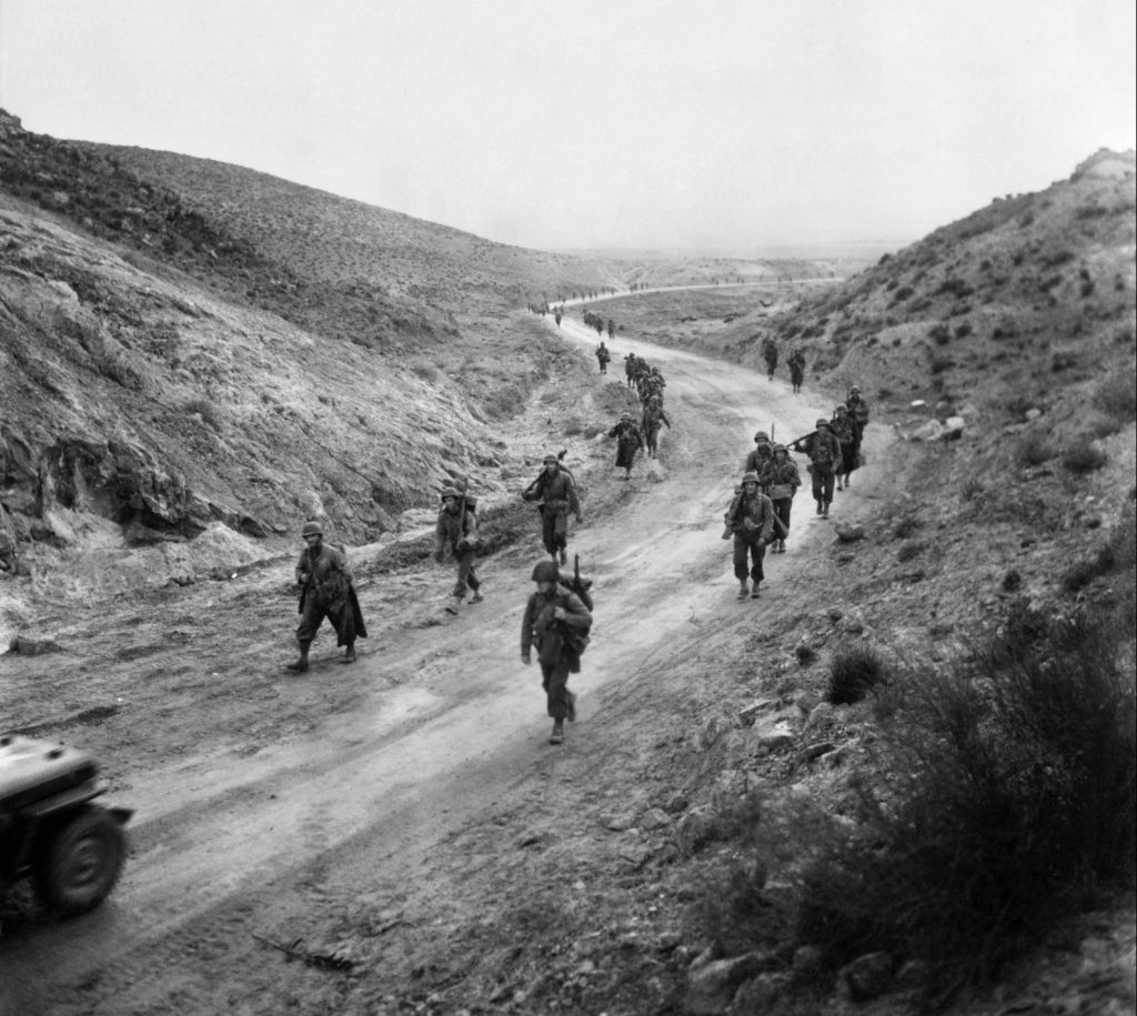 Soldiers of the U.S. 16th Infantry Regiment march through Kasserine Pass.  The Americans underestimated the German strength arrayed against them in Tunisia, which left their forward units dangerously exposed to enemy counterattack.