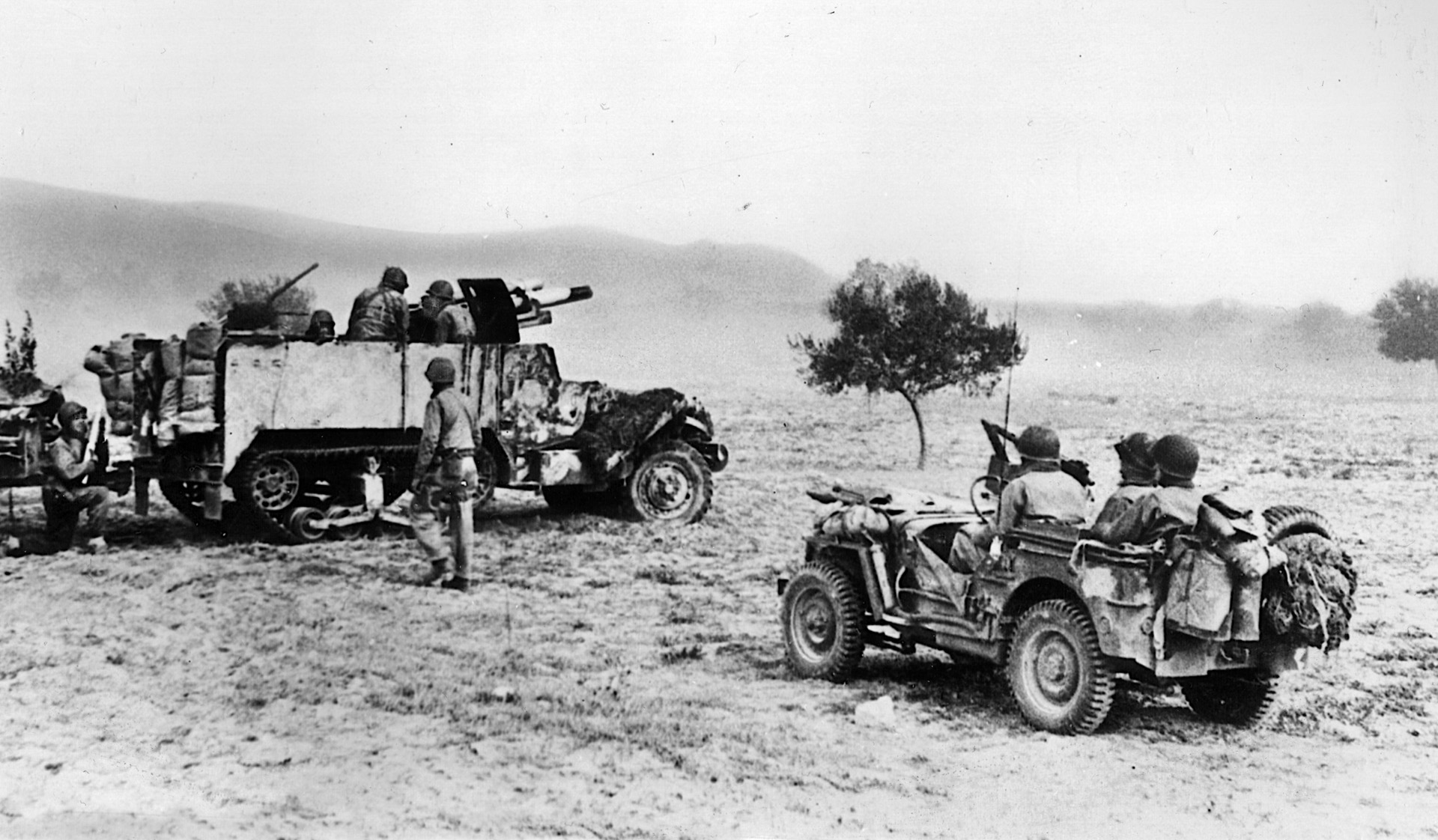 A U.S. half track mounting a heavy gun battles Axis forces in Tunisia. The Germans had superior armor and training that enabled them to prevail in their initial attack. 