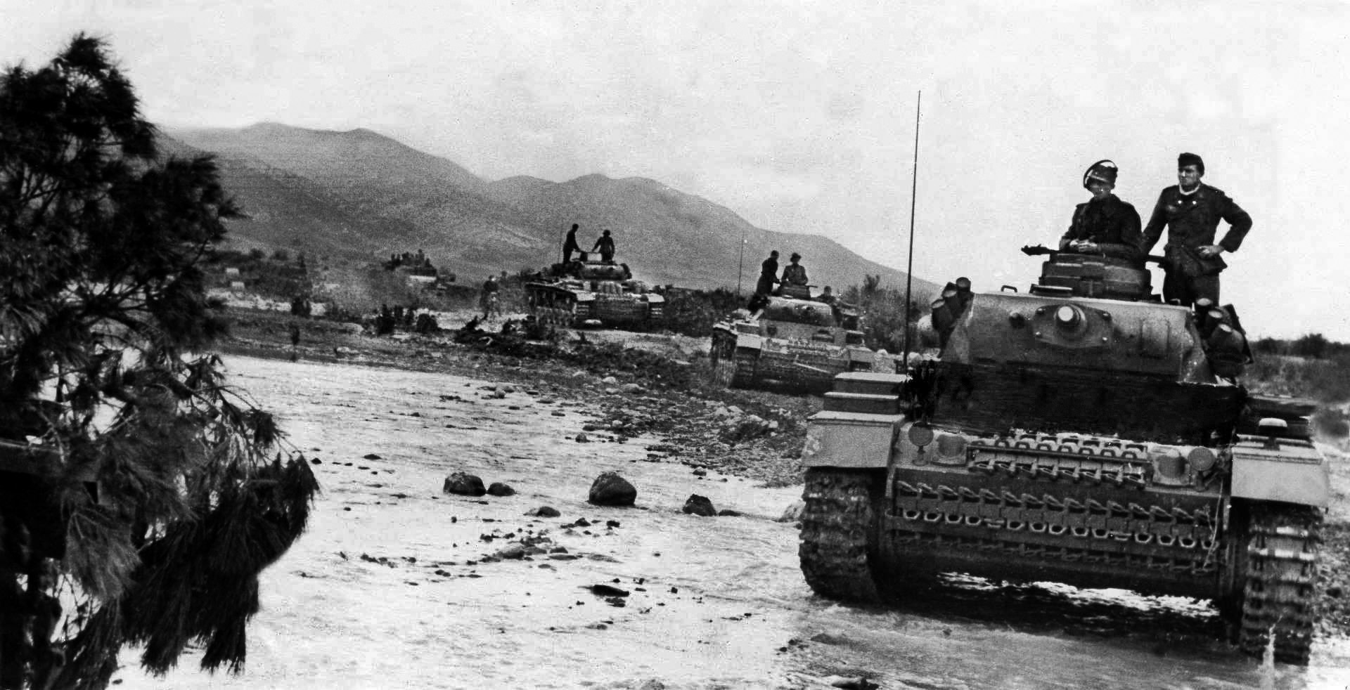 A column of German Panzer III tanks advances through the rocky terrain of central Tunisia. 