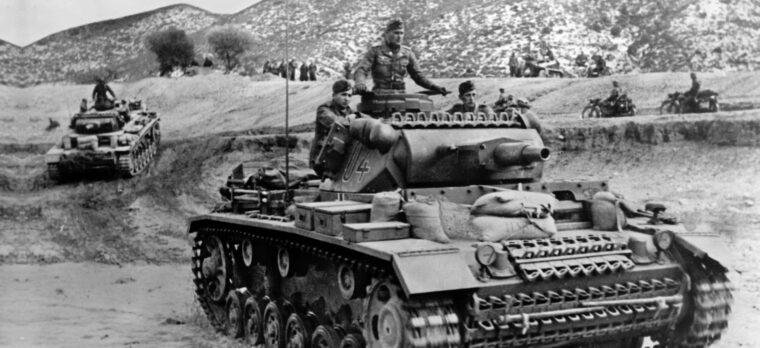 Short-barreled Panzer IVs advance through the mountains of northern Tunisia. At Kasserine Pass, German panzer columns blasted American tanks and then encircled isolated U.S. infantry units.