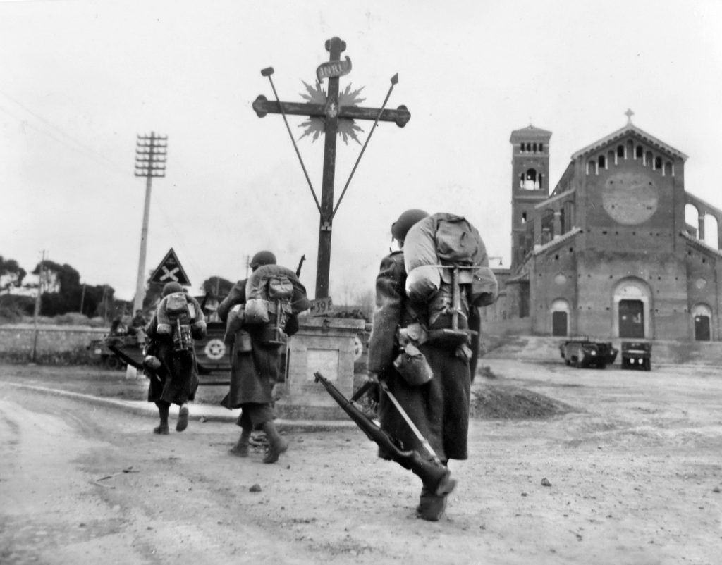 As part of U.S. VI Corps’ Operation Shingle, 45th Infantry Division replacement troops, the invasion’s second wave, march through the deserted streets of Anzio on their way to the front lines, 10 miles to the north.