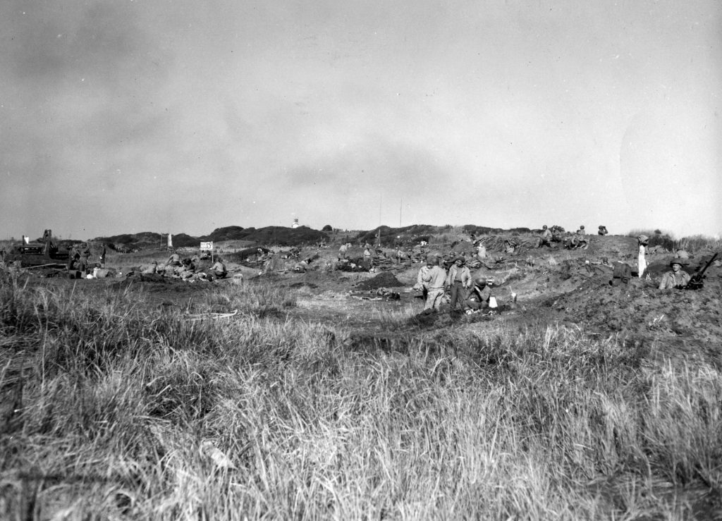 The flat terrain of the Anzio battlefield provided no cover and little concealment. Here GIs burrow into their water-filled foxholes and wait for the next German assault.