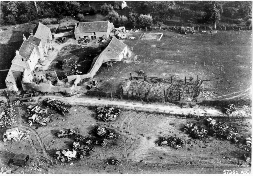 At least 16 German vehicles and their occupants lie charred and destroyed near a farmhouse in Normandy, the victims of XIX TAC.