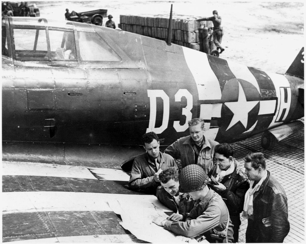 A group of fighter pilots are briefed on German infantry positions before  embarking on a mission in France. 