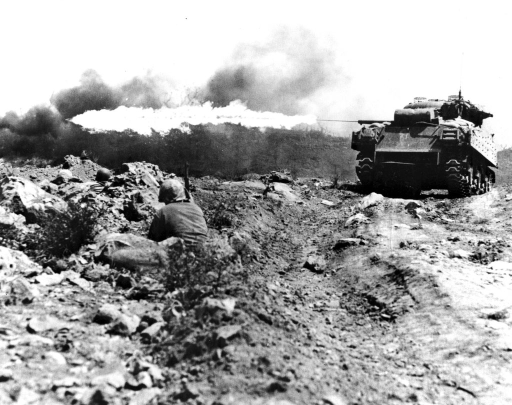 A U.S. Marine M4 Sherman tank equipped with a flamethrower attacks a Japanese bunker on Guam. The Japanese either sought to knock these tanks out swiftly or held their fire to avoid detection.