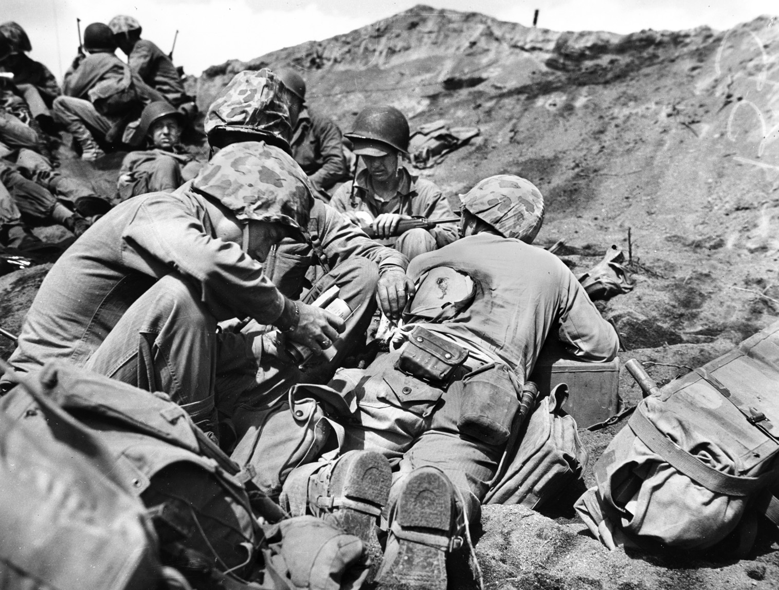 A Navy corpsman dresses the wound of a Marine who has been hit in the back while fighting on Iwo Jima. Kirby suffered a back wound during the fight for Hill 362C but kept fighting.