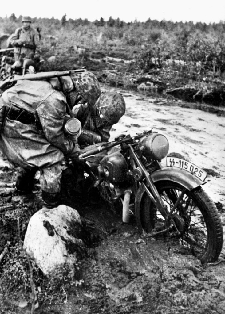 During the winter of 1945, heavy rains on the Eastern Front turned dirt roads into seas of thick mud. Here, SS soldiers struggle to free a motorcycle.