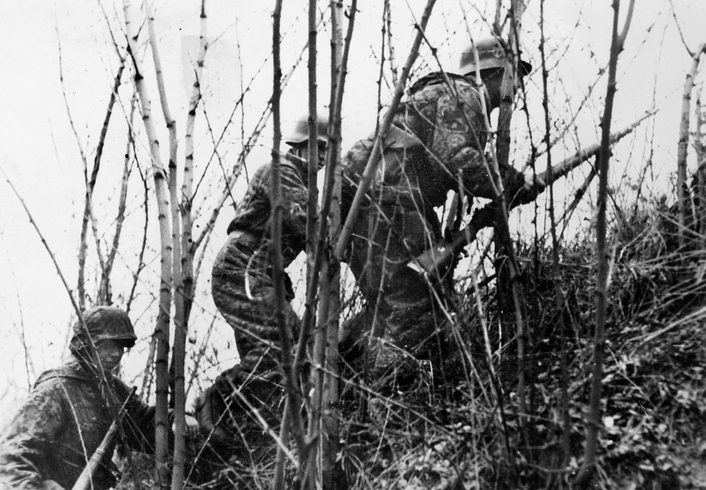  Men of the Waffen SS pick their way through the underbrush of a Hungarian hillside during their winter 1945 offensive. 