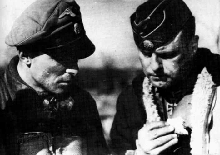 Martin Gross (right), commander of the 12th SS Panzer Division Hitlerjugend, discusses tactics with 1st SS Panzer Regiment commander <a href=