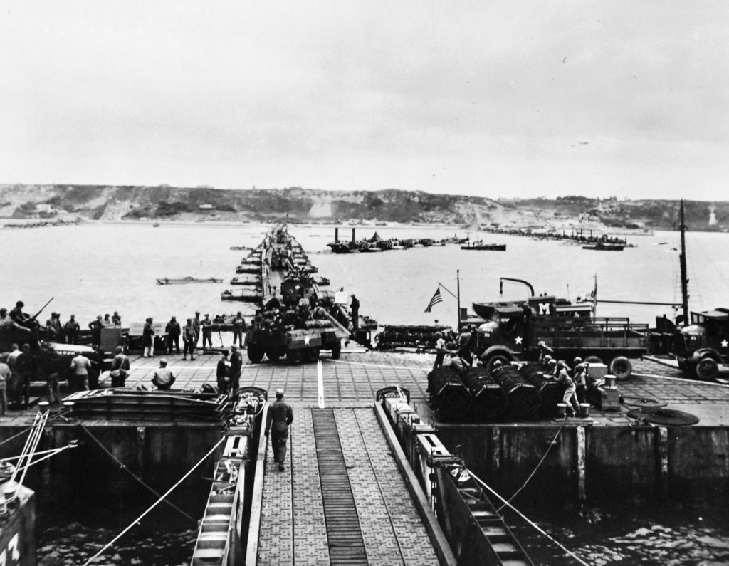 This view from the pier head of a Mulberry harbor shows the roadway to the invasion beach in Normandy. This vertically moving pier head maintained a fixed level above the changing surface of the sea.