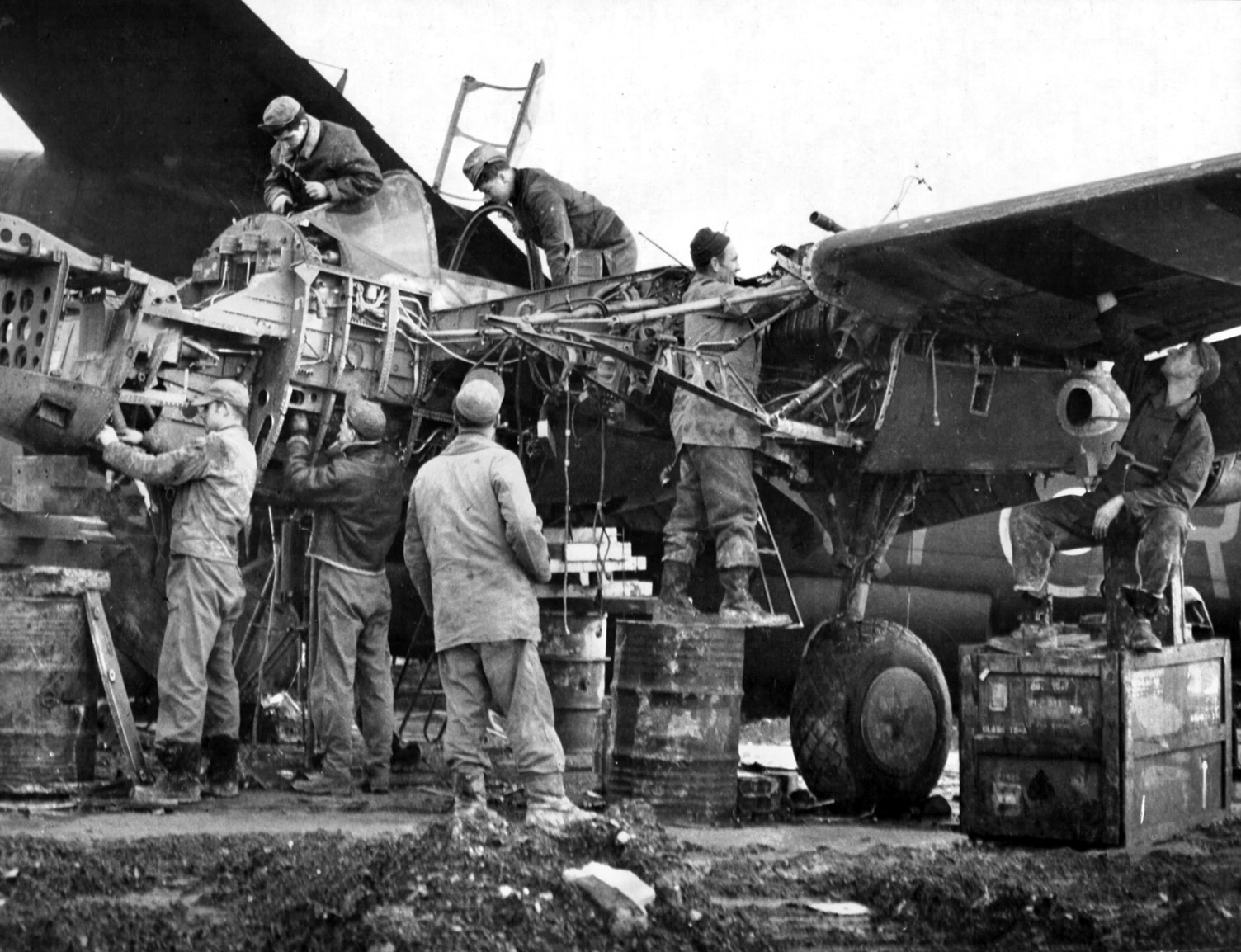 An efficient ground crew overhauls an engine and other components of a 474th Fighter Group P-38 that has flown many combat hours. The hard work of the ground crews kept the 474th P-38s flying.