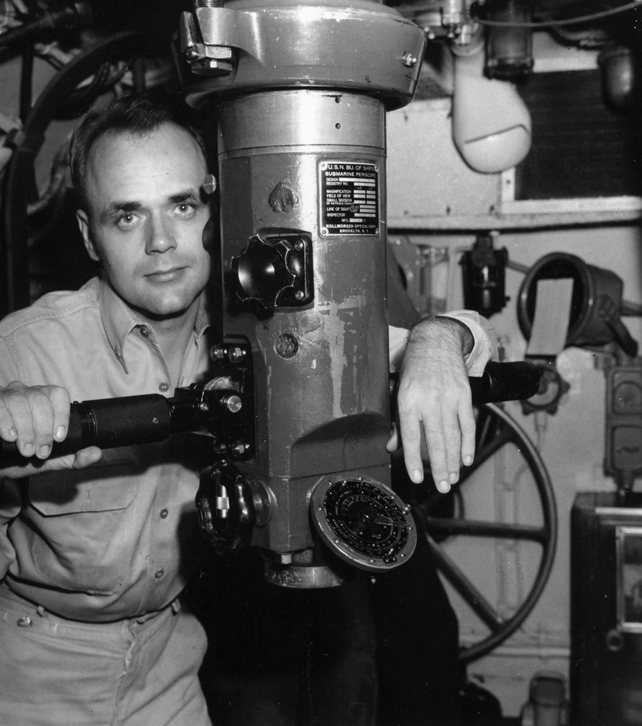 Commander Bladen D. Claggett, skipper of the submarine USS Dace, poses with his periscope aboard the vessel in September 1945.