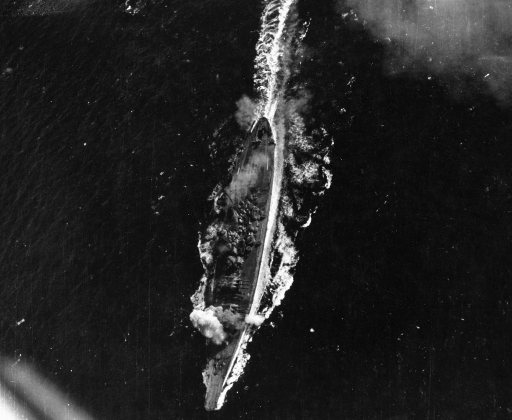 Battleship Yamato is hit by a bomb near her forward 460mm gun turret during attacks by U.S. aircraft. The hit did not produce serious damage. 