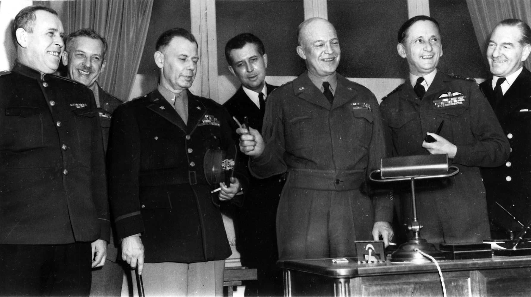 Senior Allied officers gather after the German surrender at Reims. General Dwight Eisenhower holds the pens used to sign the surrender documents. At Eisenhower’s right is his chief of staff, General Walter Bedell Smith, and to his left is Air Chief Marshal Arthur Tedder.