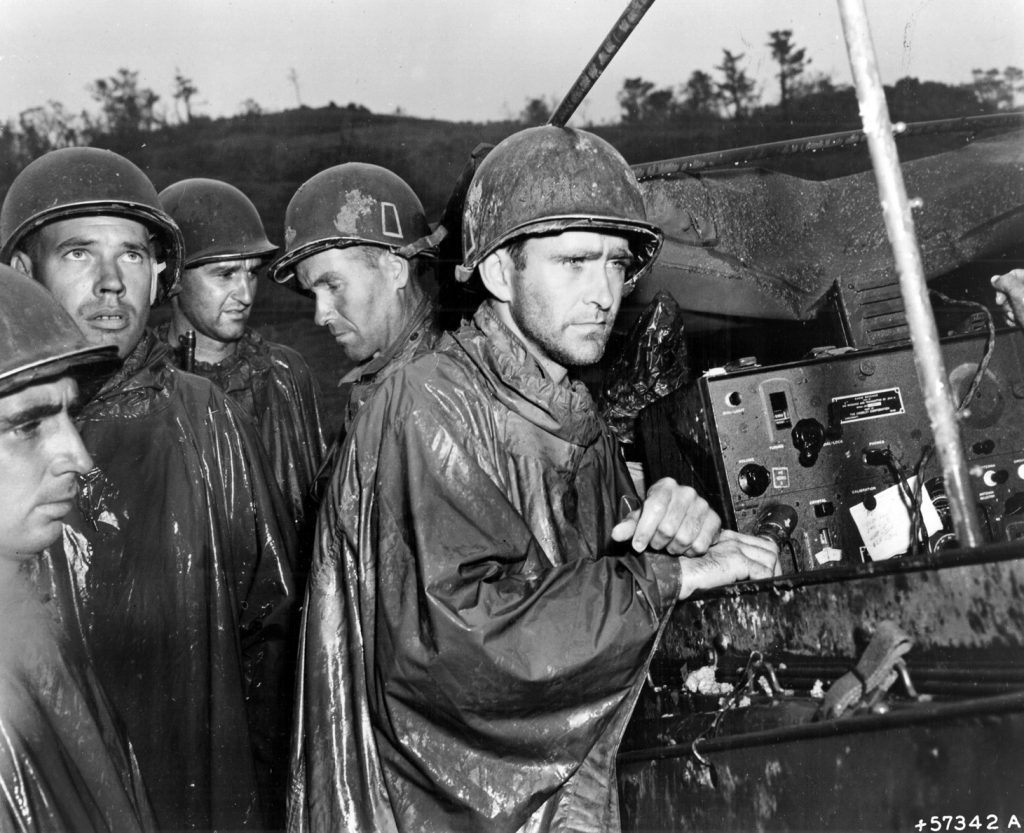 Soldiers of the U.S. Army’s 77th Infantry Division, embroiled in a bloody struggle with Japanese troops for control of the island of Okinawa in the Pacific, listen to a radio for news of the surrender of Nazi Germany on May 8, 1945. World War II in the Pacific lasted four more months.