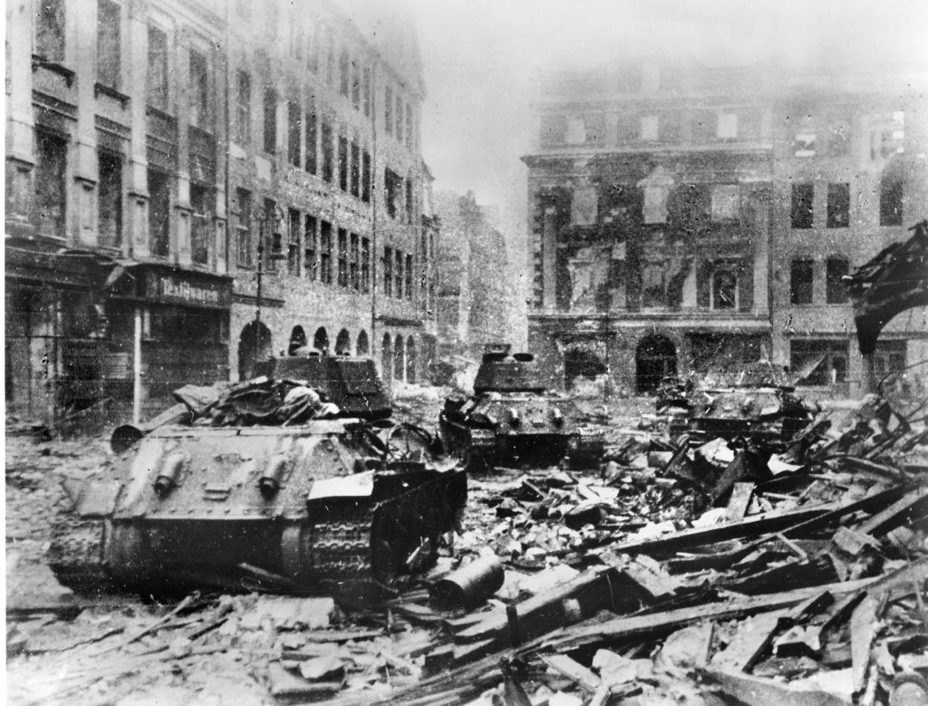 Soviet tanks move through the rubble-strewn streets of Berlin. During the last days of World War II the German capital city was ravaged by the marauding Soviet Red Army.