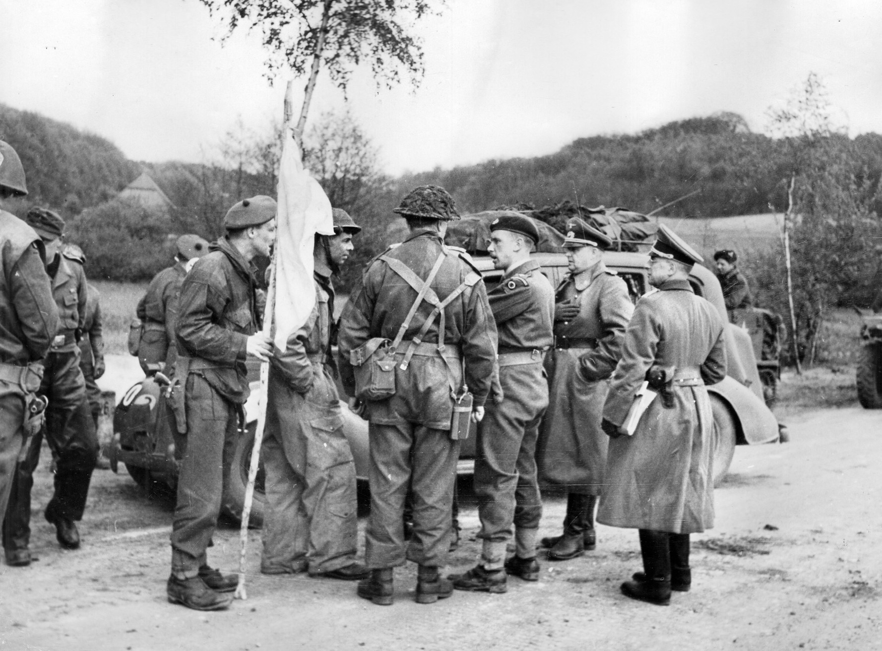 A British naval officer held in a POW camp for four years leads German officers through British lines as they make their way to conclude terms for the surrender of the city of Hamburg, Germany, on May 2, 1945. British troops entered the major port city the next day.