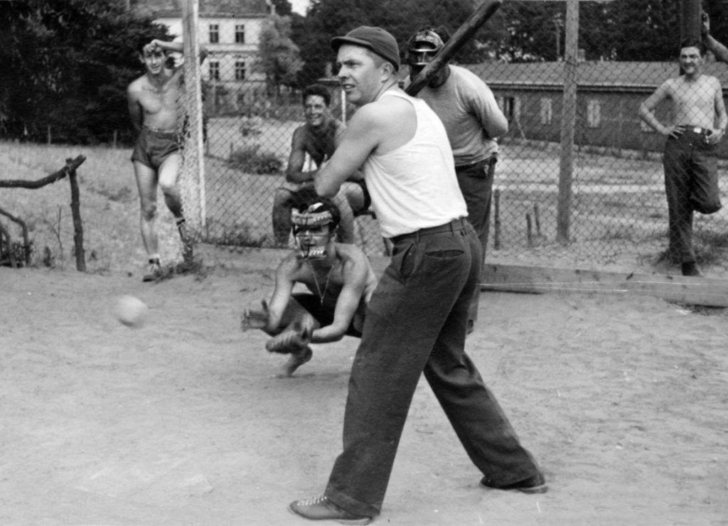 POWs at Oflag 64 play baseball to pass the time until liberation. The prisoners at the POW camp were well treated until they were evacuated by their German captors as the Russian Army neared the camp.