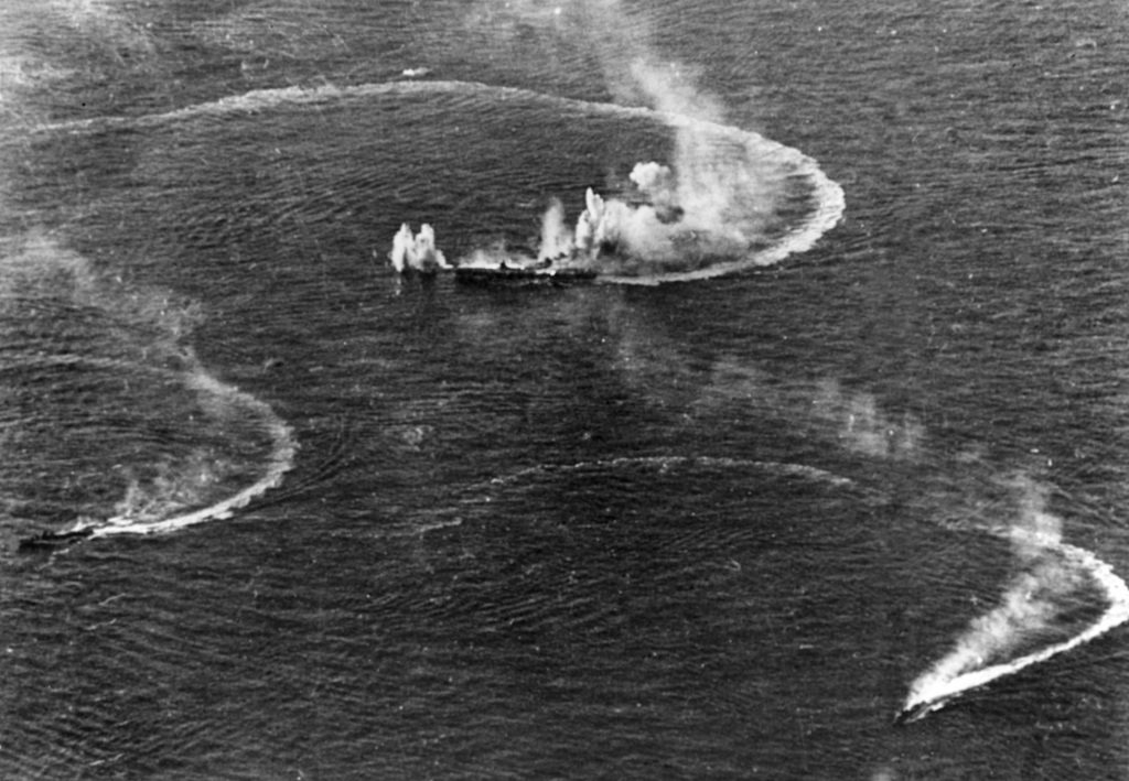 Late on the afternoon of June 20, the Japanese aircraft carrier Zuikaku, center, and a pair of escorting destroyers maneuver violently to evade torpedoes and bombs from attacking American aircraft. Zuikaku was hit by several bombs during the raid, but managed to survive the Battle of the Philippine Sea.