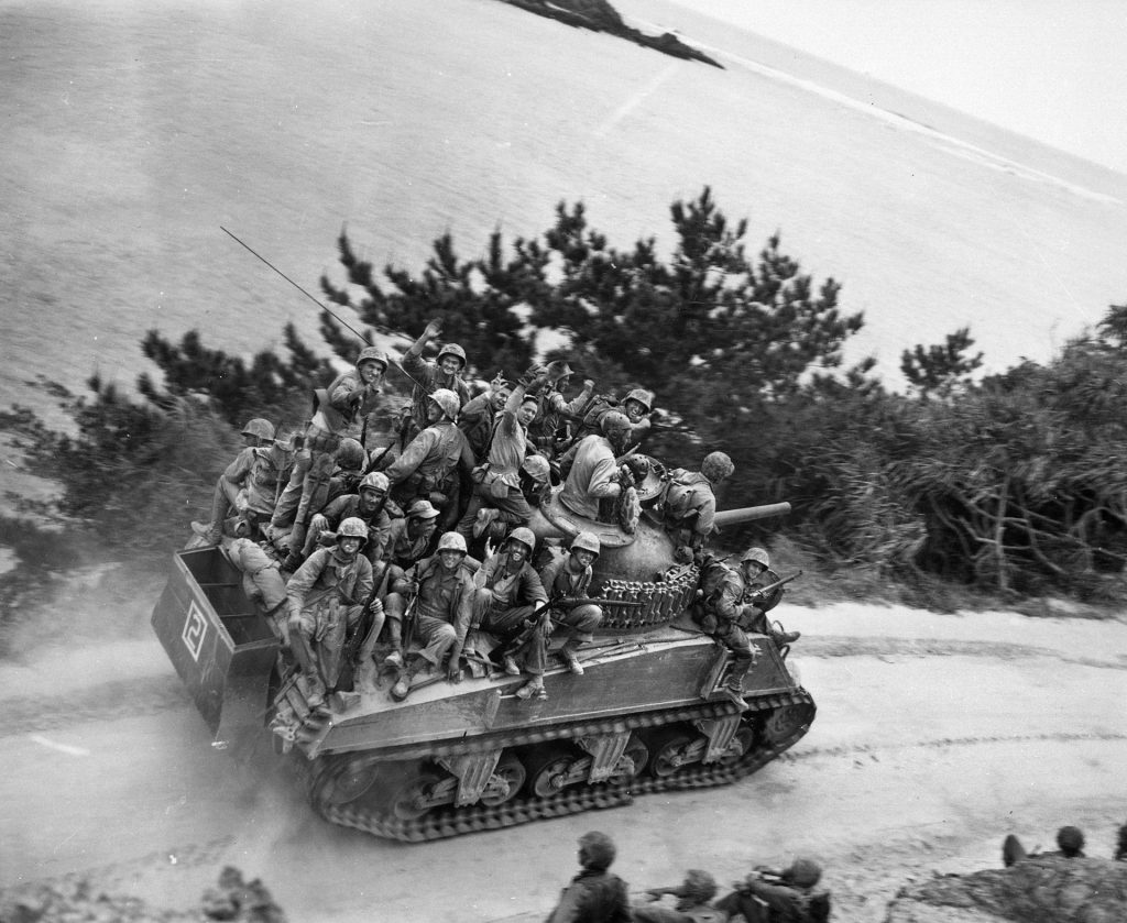 During the U.S. 6th Marine Division drive to the west coast of Okinawa in April 1945, men of the 29th Marines hitch a ride atop an M4A3 Sherman of Company A, 6th Tank Battalion. 