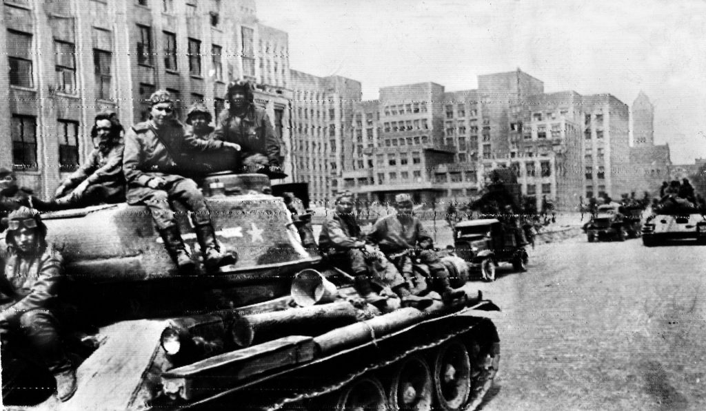 On the 11th day of Operation Bagration, Red Army soldiers ride aboard tanks and trucks through the city of Minsk, capital of White Russia. Marshal Konstantin Rokossovsky played a key command role in the Soviet offensive.