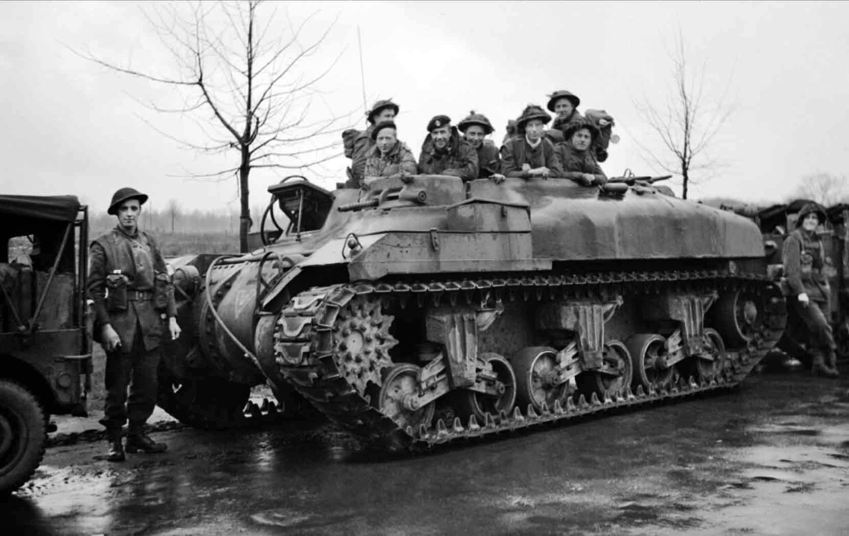 Soldiers of the 53rd Welsh Division are riding in a Kangaroo personnel carrier manufactured from the modified chassis of the M4 Sherman medium tank.