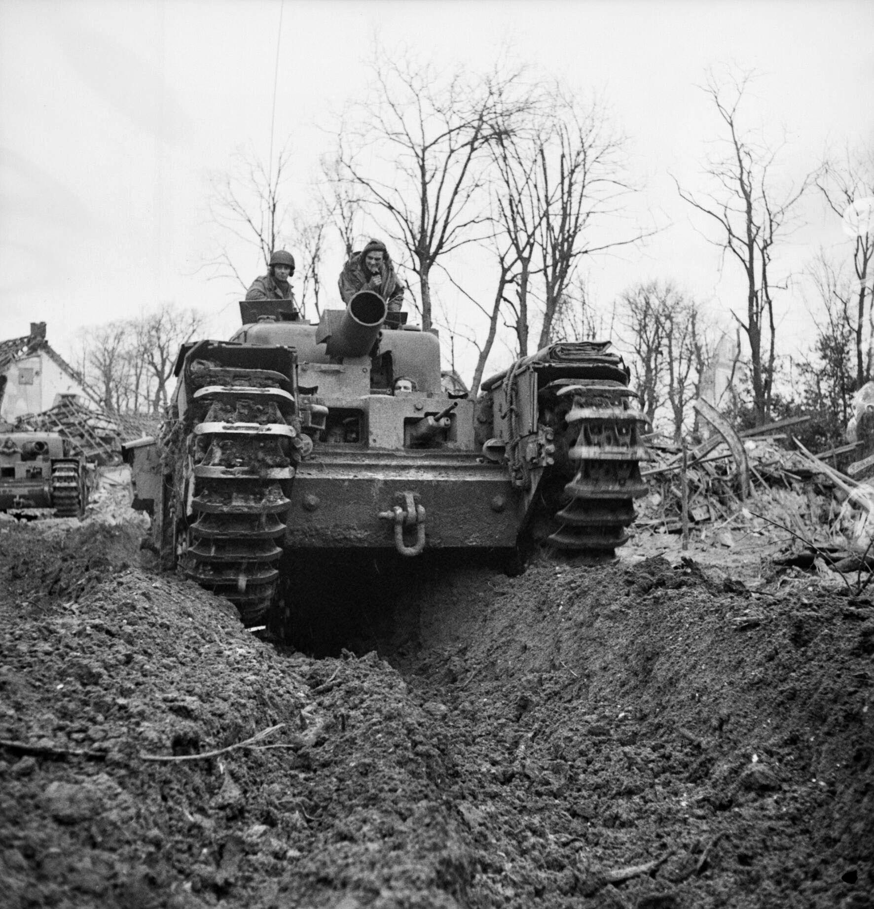 A Churchill AVRE tank armed with a heavy spigot mortar grinds forward through the mud near Cleve, February 12, 1945. 