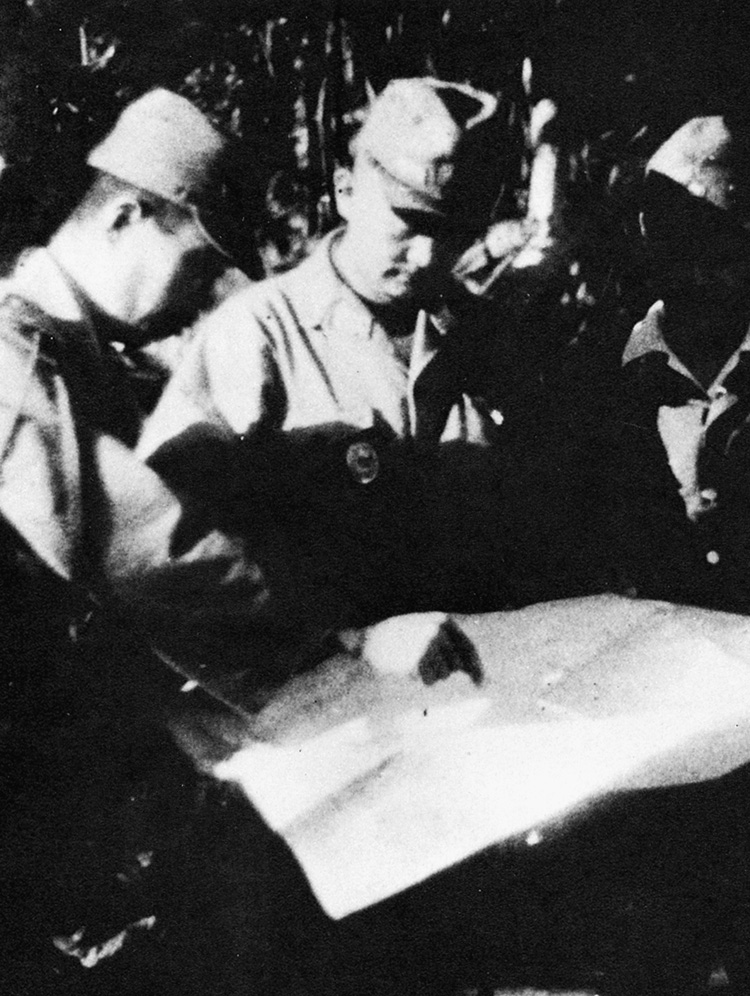 General Kuribayashi (center) looks over a plan of underground defenses at Iwo Jima.