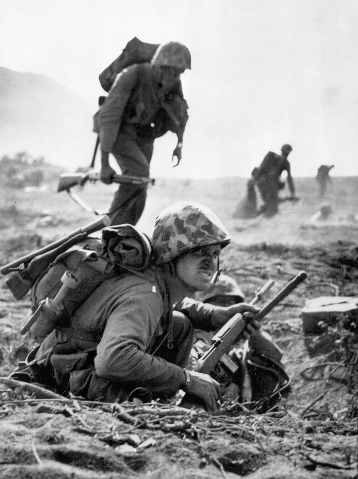 A U.S. Marine prepares to leave his position as his unit moves across an airfield on Iwo Jima.