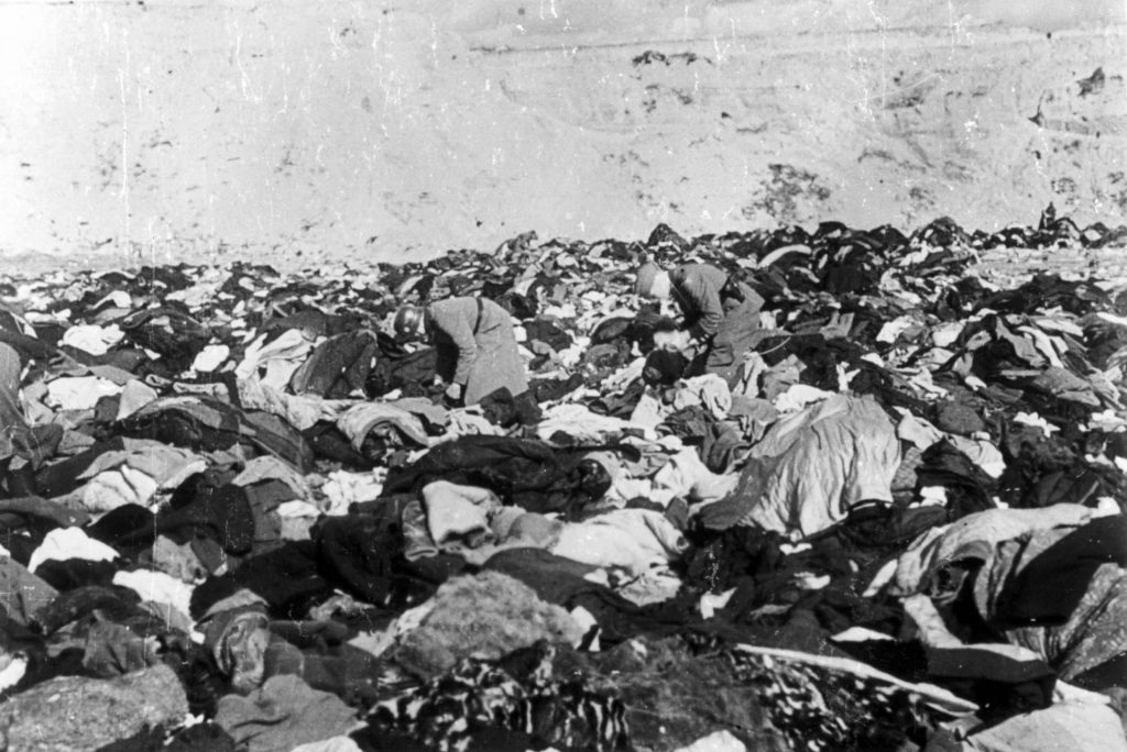 Two German soldiers, probably looking for valuables, pick through the corpses of nearly 34,000 Jews killed at Babi Yar, a ravine outside Kiev, in September 1941.