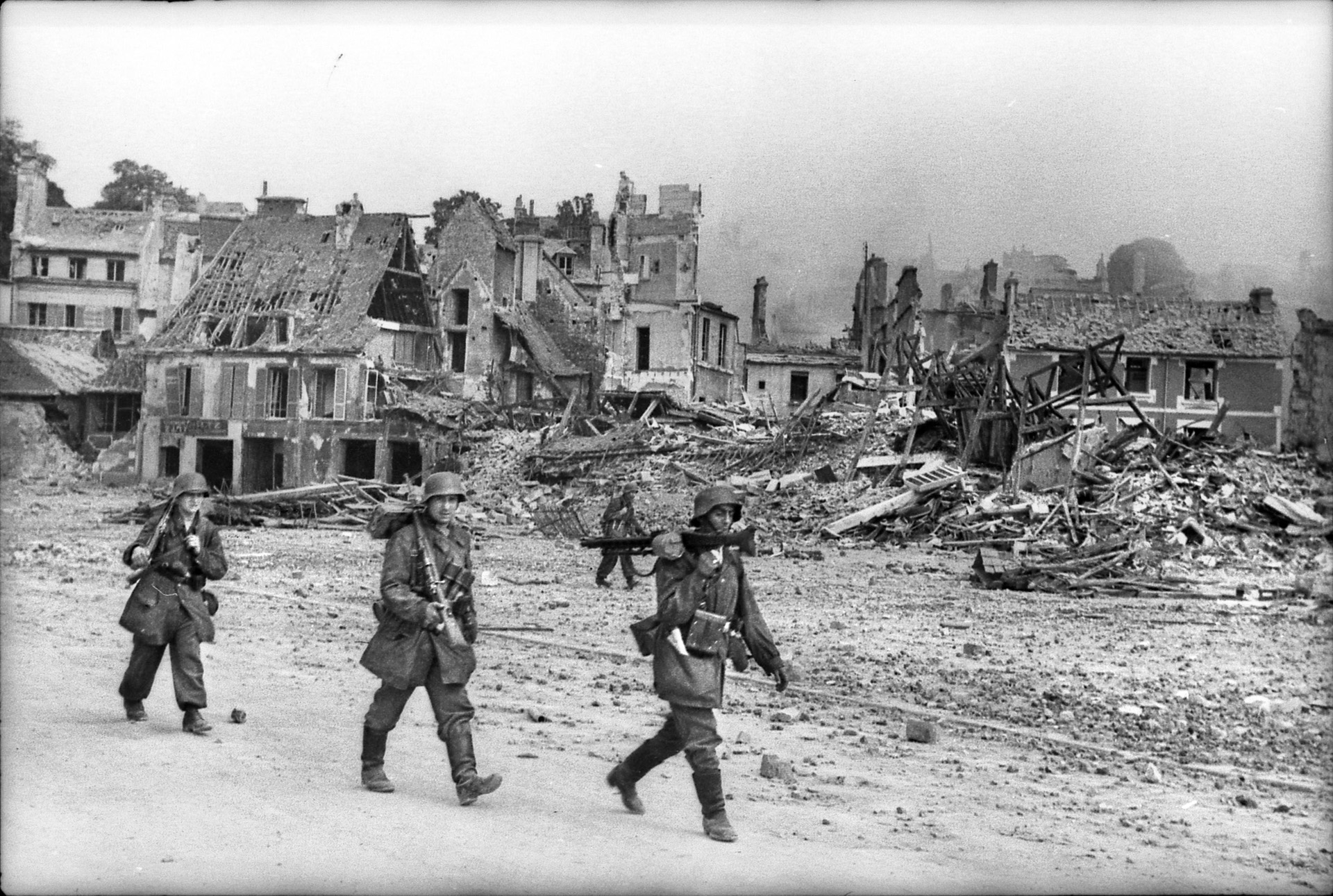 A German MG-42 crew moves through Caen, which was almost totally destroyed during the month-long battle, to take up a new position.