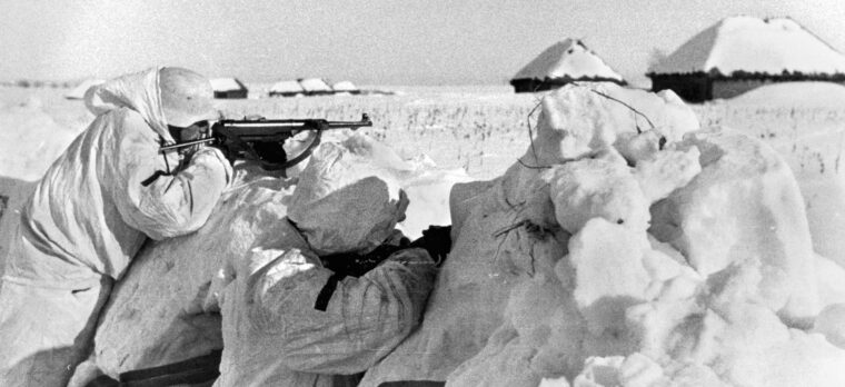 German soldiers in winter camouflage defend their lines against oncoming Russians.