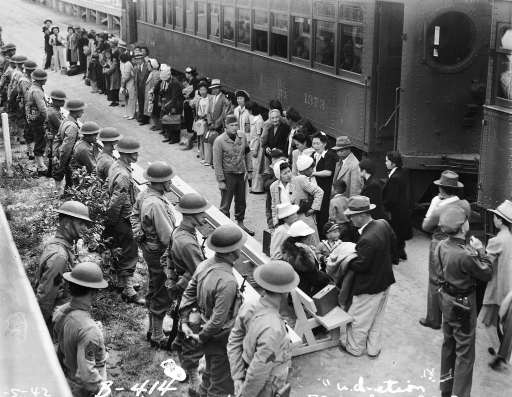 A group of Japanese Americans prepares to board a passenger train for an internment camp under the watchful eyes of U.S. soldiers. Many of the internees were forced to sell their belongings and never recovered financially or emotionally from the trauma of internment. 