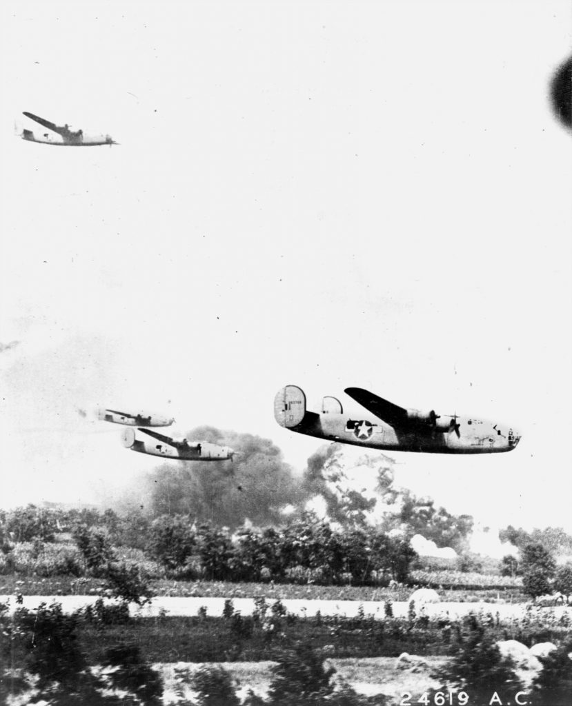 Smoke and flames billow from refinery structures at Ploesti, Romania, as B-24 Liberators  fly low over their target during the difficult hours of Operation Tidal Wave.