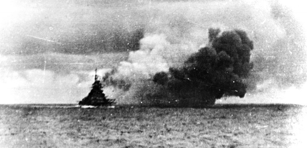 In this photograph taken from the deck of the German cruiser Prinz Eugen, the Bismarck fires  its 15-inch guns at the battleship Prince of Wales and battlecruiser Hood.