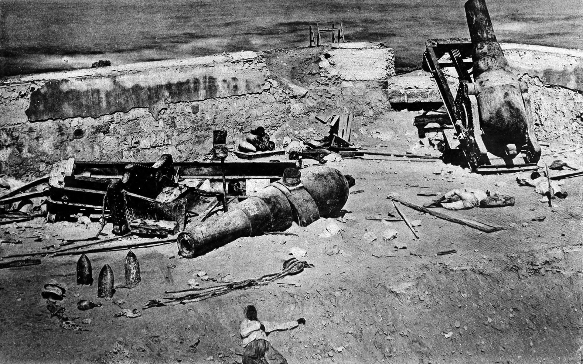 Disabled guns of a smashed shore battery and Egyptian casualties show the devastation wrought by the British fleet’s guns. 