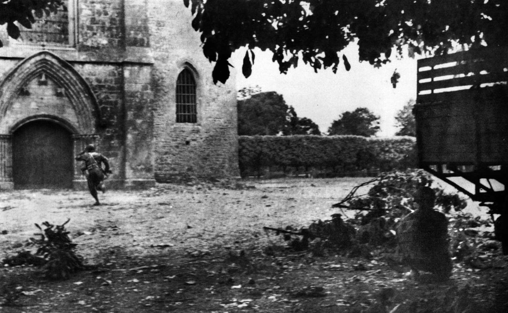 Seeking cover from incoming German artillery shells on June 6, 1944, men of the 505th Parachute Infantry Regiment, 82nd Airborne Division run for the chapel in the town of Ste-Mère-Église. 