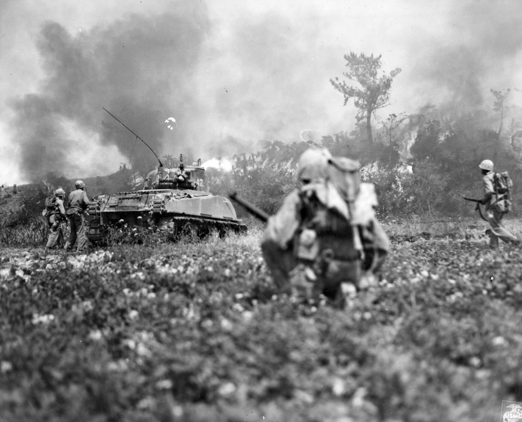 Marines follow a flame-throwing Sherman tank into the blazing jungle on Okinawa as part as the 82-day battle. Both sides sufered horrendous casualties.