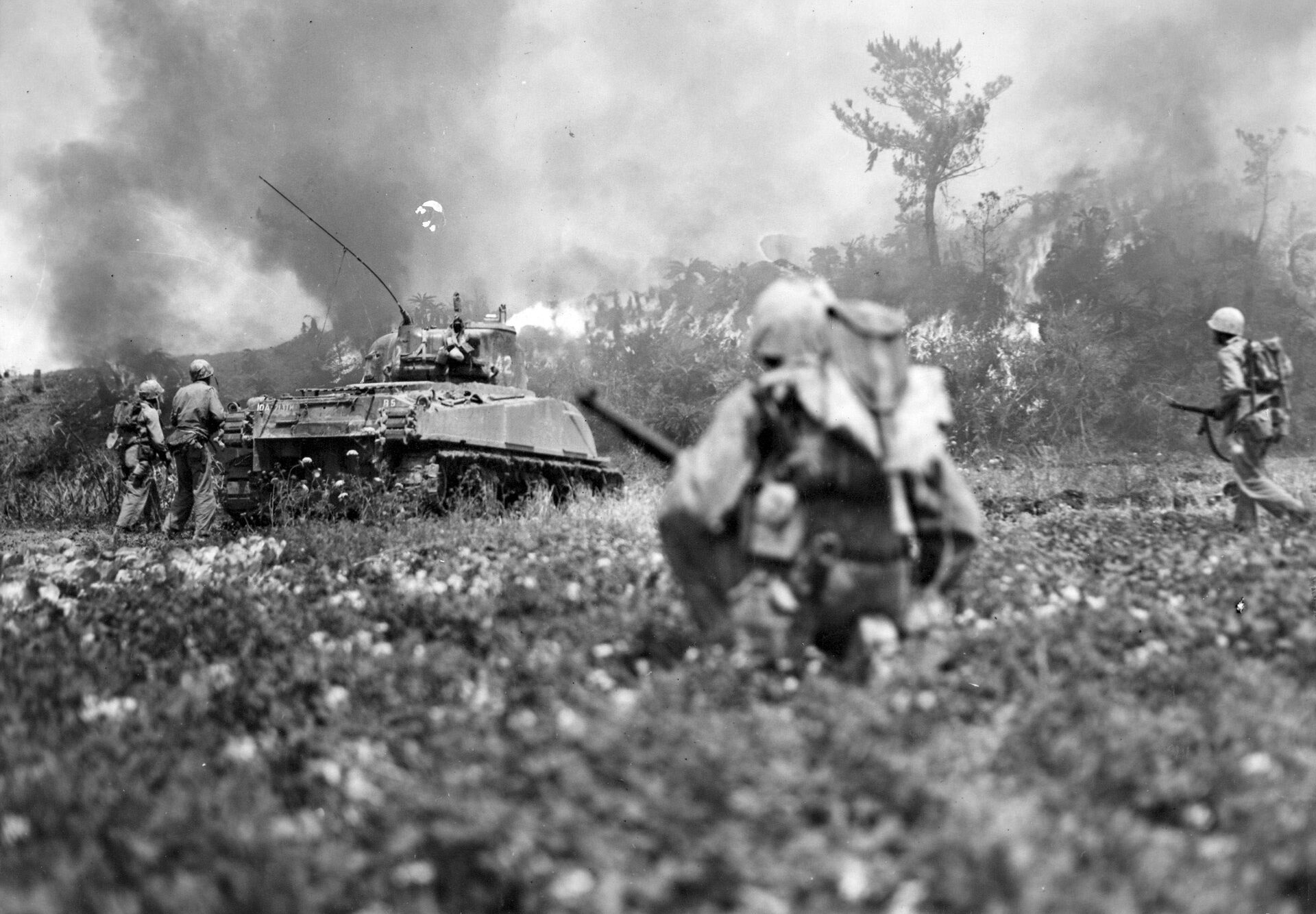 Marines follow a flame-throwing Sherman tank into the blazing jungle on Okinawa as part as the 82-day battle. Both sides sufered horrendous casualties.