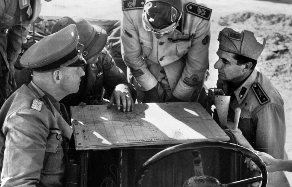 Rommel (left) and Italian officers pore over a map. Not only did the “Desert Fox” hold a dim view of his jittery Italian allies, but he was frustrated by Hitler’s continual interference in the conduct of the North Africa campaign.